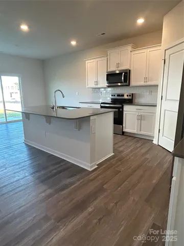 a kitchen with granite countertop a sink and steel appliances