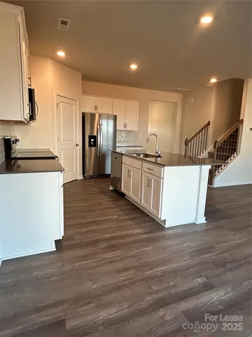 a kitchen with stainless steel appliances granite countertop a stove a sink and a refrigerator