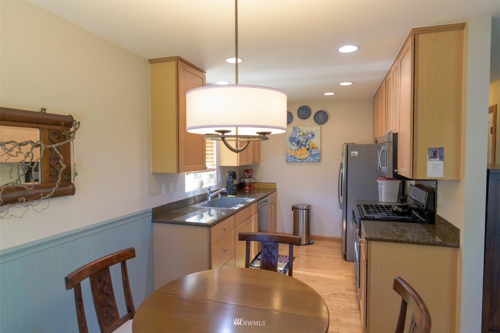 713 Sylvan Way Bremerton, WA 98310 - Photo 8 of 32 a kitchen with sink a refrigerator and chairs