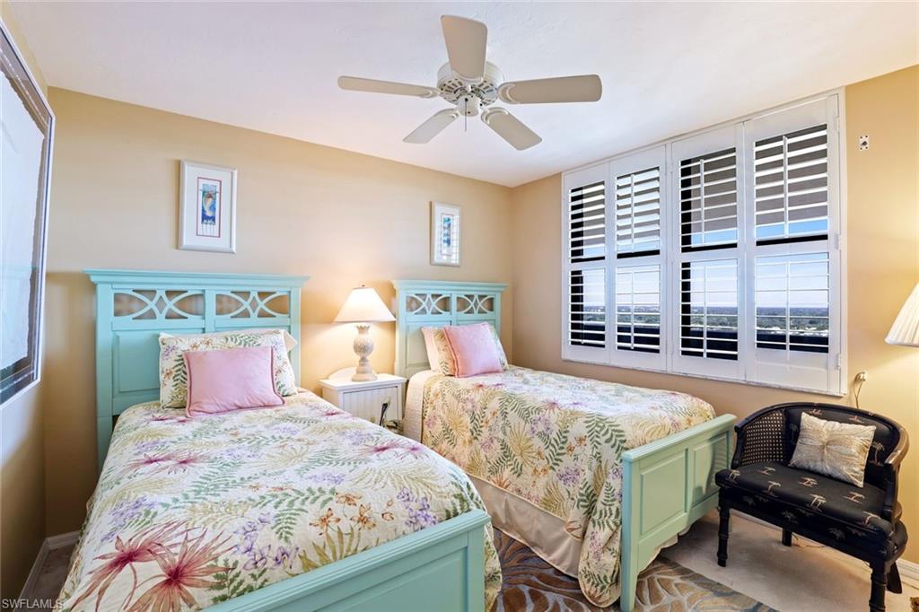 6573 Marissa Loop, Unit 1902 Naples, FL 34108 - Photo 11 of 21 a bedroom with two beds and a chandelier