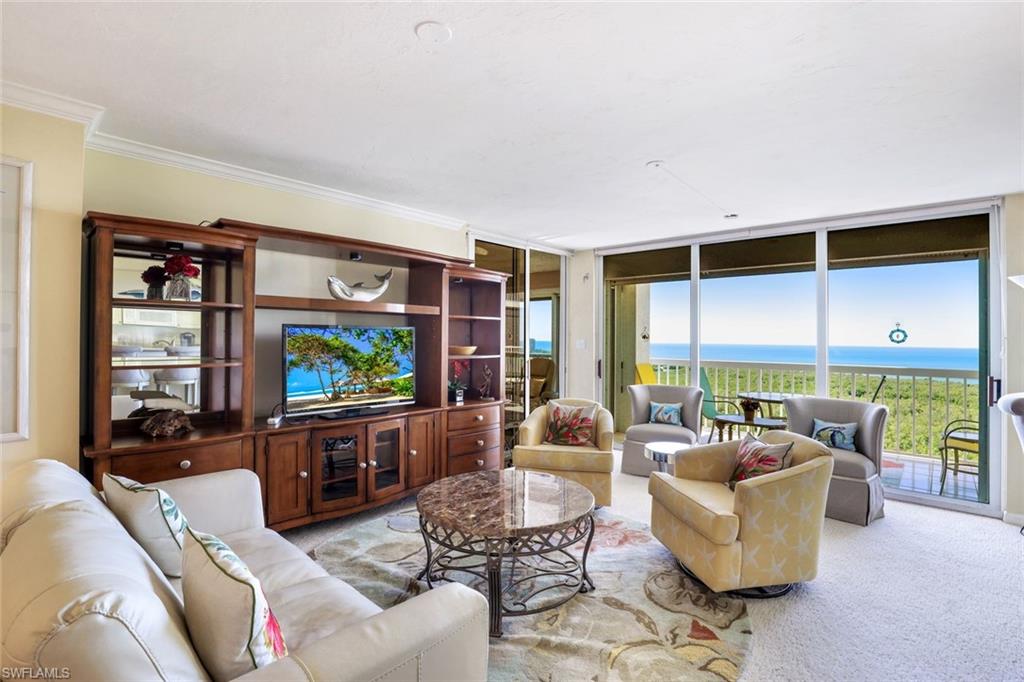 6573 Marissa Loop, Unit 1902 Naples, FL 34108 - Photo 2 of 21 a living room with furniture and a flat screen tv