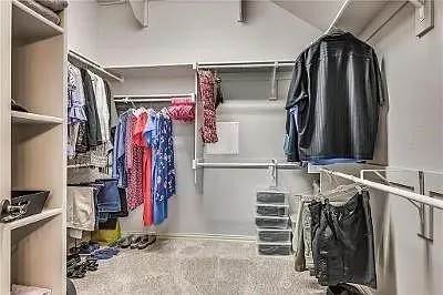 a view of walk in closet with clothes and shoes