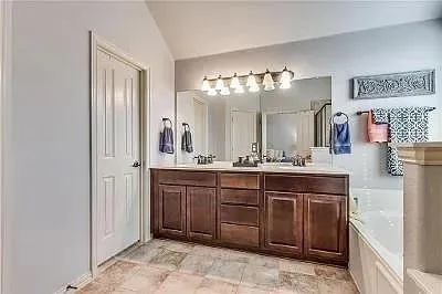 a spacious bathroom with a double vanity sink and a mirror
