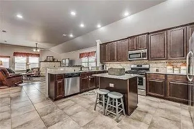 a kitchen with stainless steel appliances granite countertop a stove top oven a sink dishwasher and cabinets