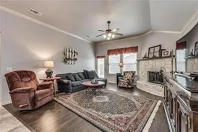a living room with furniture a fireplace and a chandelier