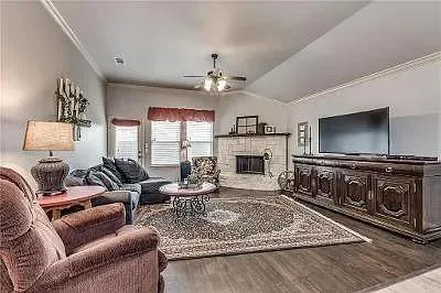 a living room with furniture a flat screen tv and a fireplace