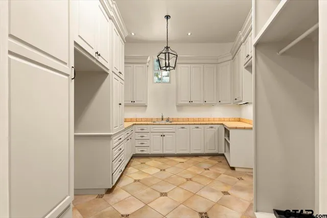 a large white kitchen with granite countertop a sink