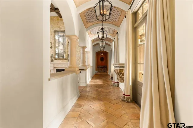 a view of a hallway with a dining table & chairs