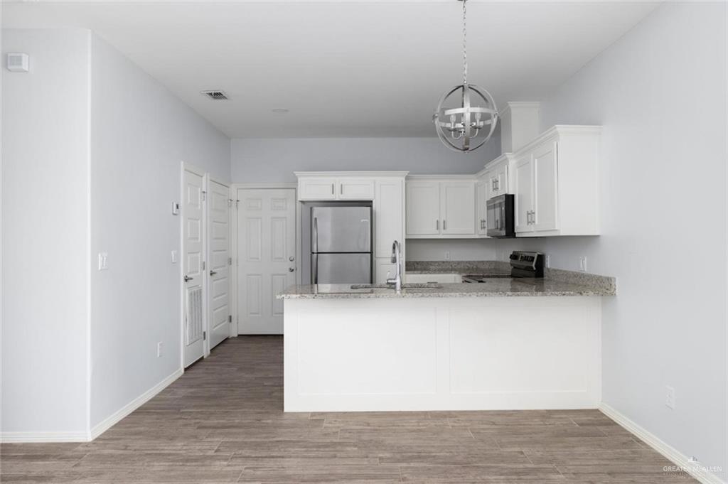 304 Retama Lane, Unit 2 Weslaco, TX 78596 - Photo 2 of 10 a view of kitchen with granite countertop stainless steel appliances a sink and a refrigerator