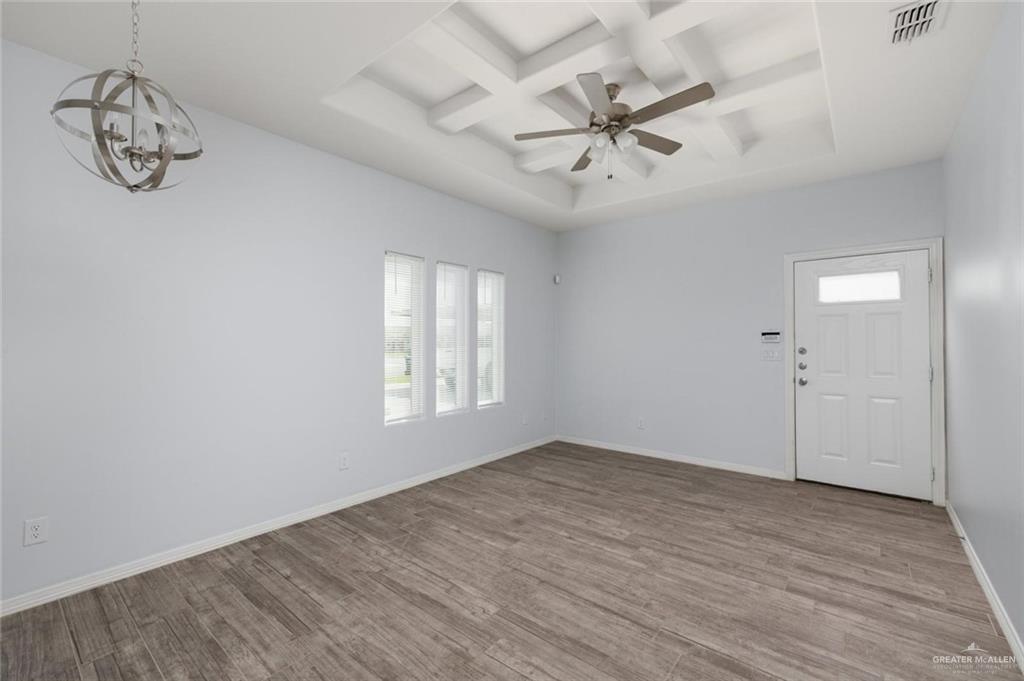 304 Retama Lane, Unit 2 Weslaco, TX 78596 - Photo 3 of 10 wooden floor in an empty room with a window