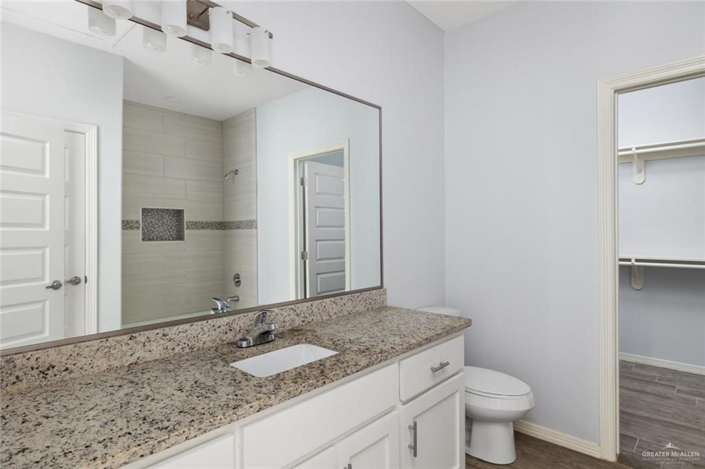 304 Retama Lane, Unit 2 Weslaco, TX 78596 - Photo 5 of 10 a bathroom with a granite countertop sink and a mirror