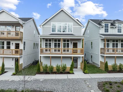 a front view of a house with a yard and potted plants