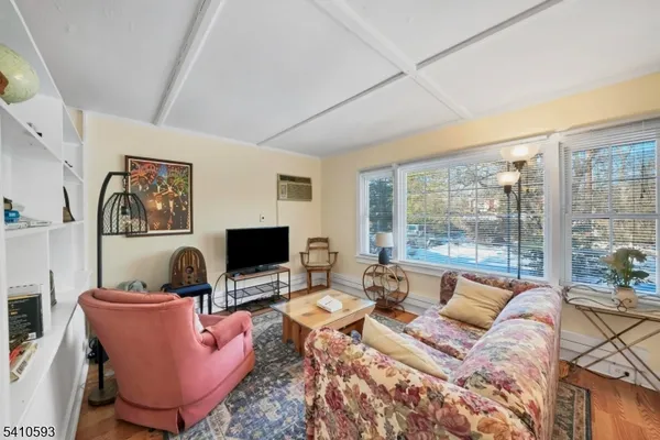 a living room with furniture a flat screen tv and a floor to ceiling window