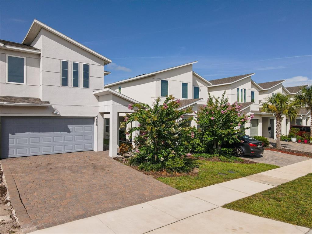 3470 Beau Road Kissimmee, FL 34746 - Photo 2 of 40 a front view of a house with a yard and garage