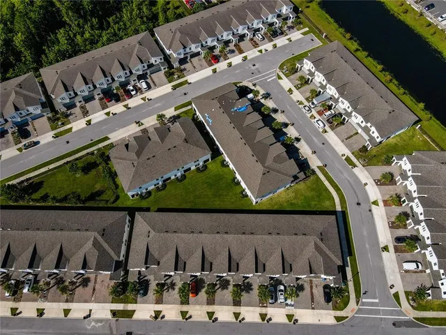 an aerial view of a city with lots of residential buildings ocean and mountain view in back