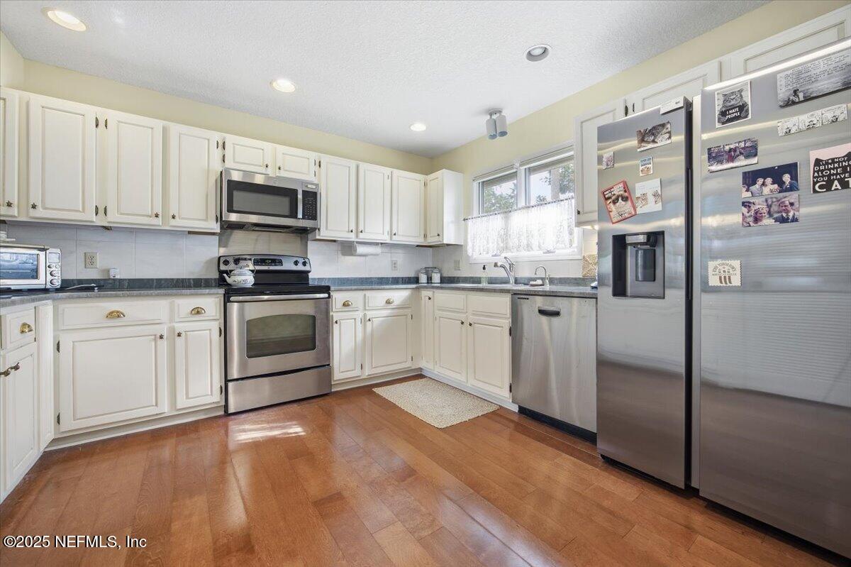 84 Players Club Villas Road Ponte Vedra Beach, FL 32082 - Photo 4 of 20 a kitchen with stainless steel appliances granite countertop a refrigerator sink and white cabinets