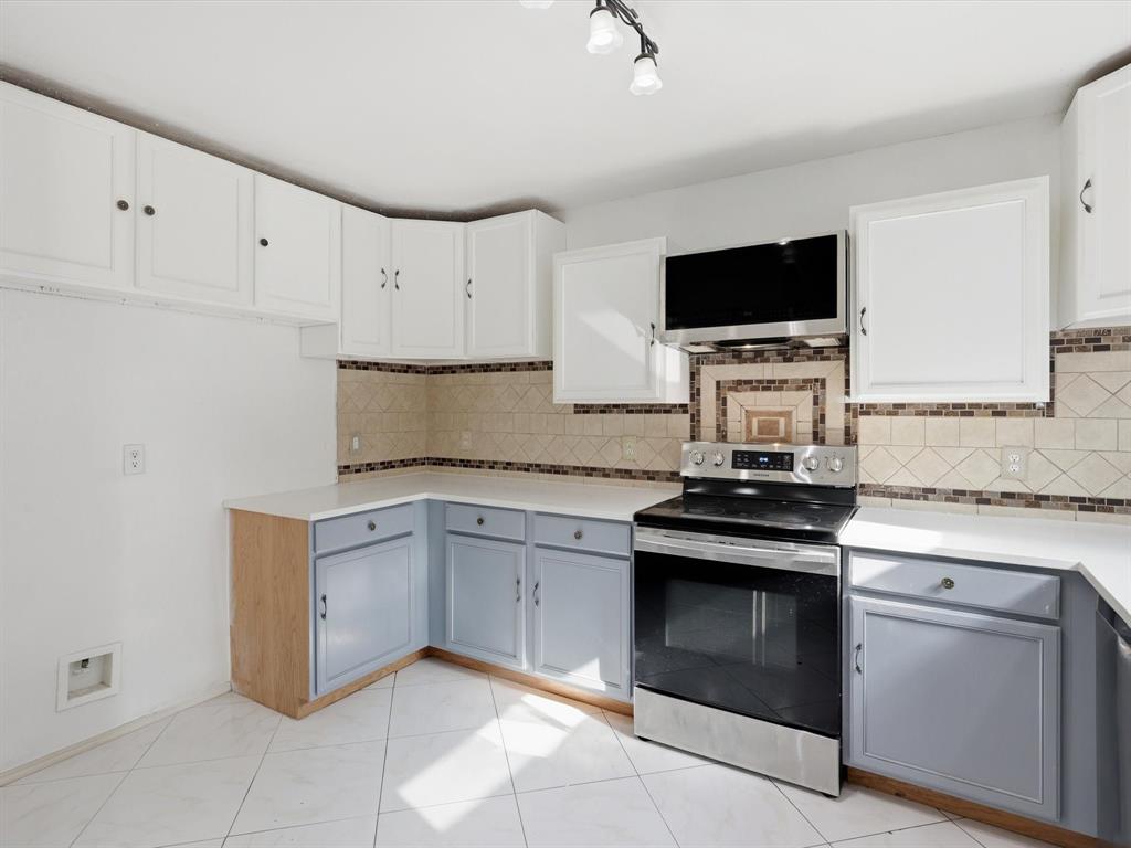 918 Blue Sky Drive Arlington, TX 76002 - Photo 11 of 24 a kitchen with granite countertop white cabinets and stainless steel appliances