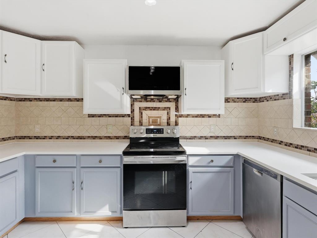 918 Blue Sky Drive Arlington, TX 76002 - Photo 12 of 24 a kitchen with granite countertop a stove and a microwave