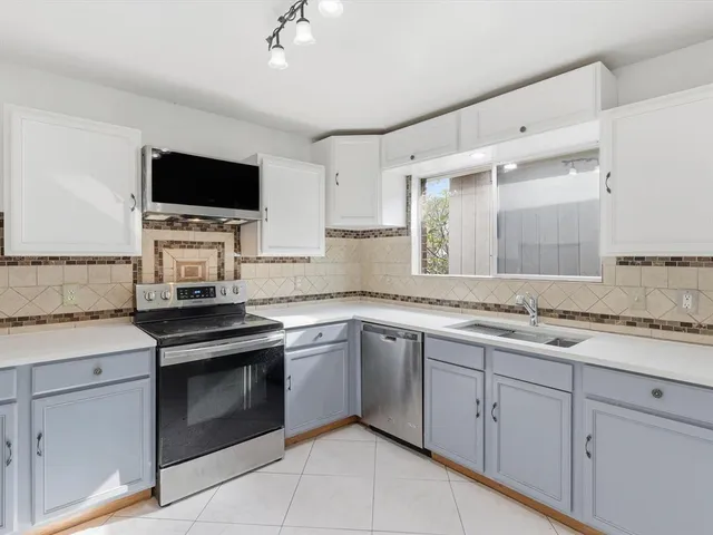 a kitchen with a sink stove and microwave