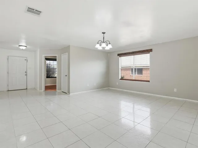 an empty room with chandelier and windows