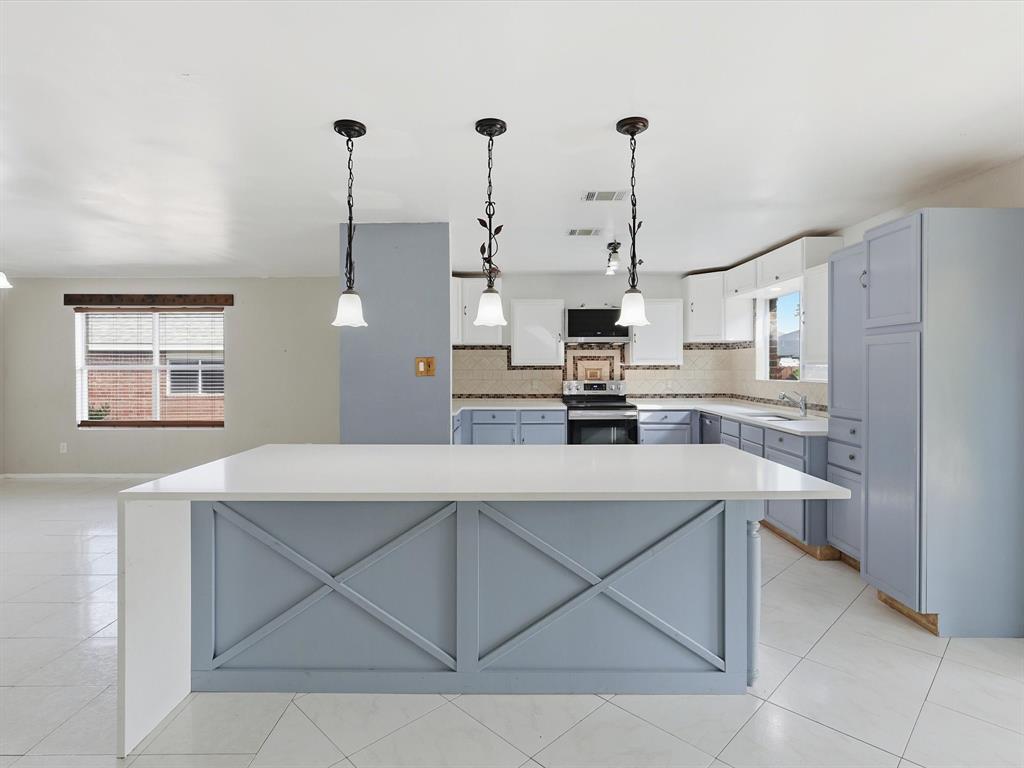 918 Blue Sky Drive Arlington, TX 76002 - Photo 9 of 24 a kitchen with a sink a stove a refrigerator and white cabinets