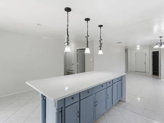 a view of a kitchen with a sink and an empty room