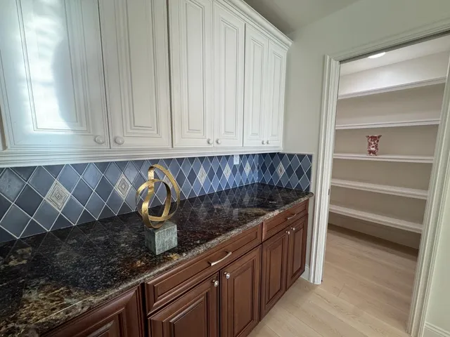 a kitchen with granite countertop a sink and cabinets