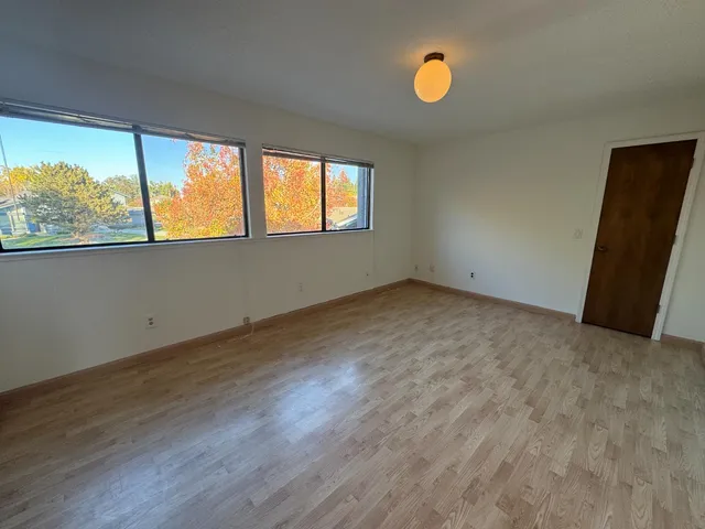 wooden floor in an empty room with a window