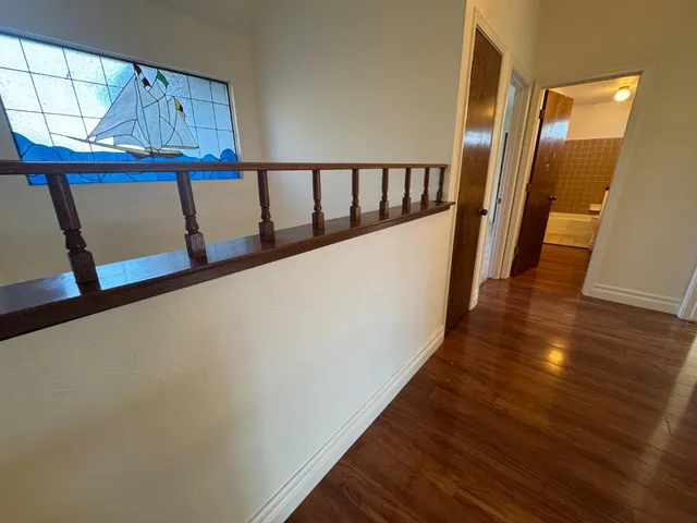 a view of a living room with wooden floor and a window