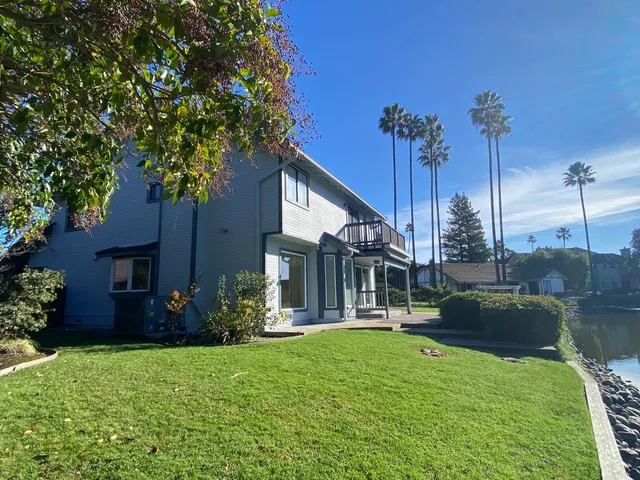 a view of a house with a yard and potted plants