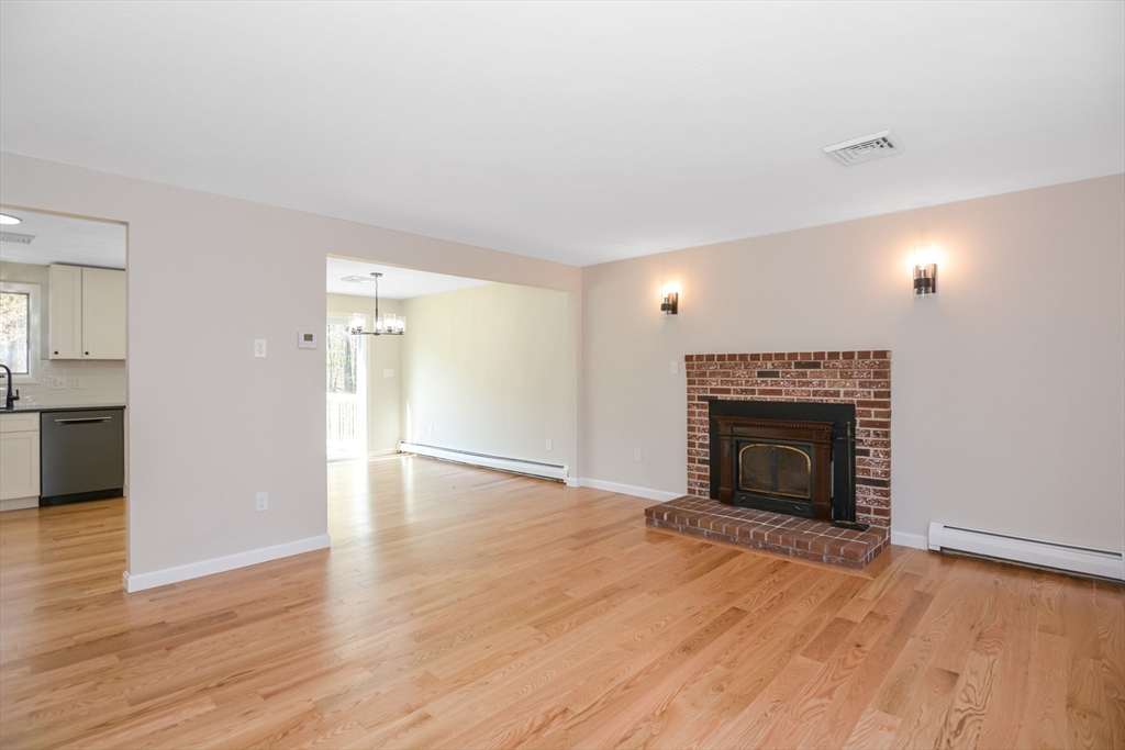21 North End Road Townsend, MA 01469 - Photo 7 of 39 a view of an empty room with wooden floor fireplace and a window