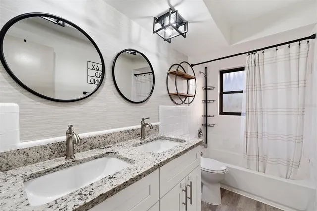 a bathroom with a granite countertop double vanity sink and a mirror