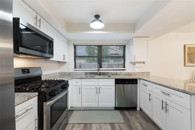 a kitchen with stainless steel appliances granite countertop a sink and a stove