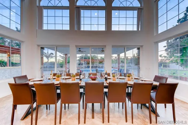 a dining room with wooden floor a chandelier fan a wooden table and chairs