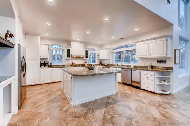 a kitchen with stainless steel appliances granite countertop a sink counter space cabinets and a large window
