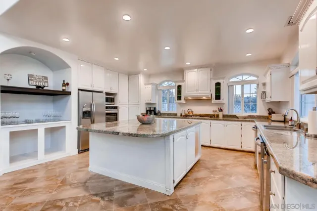 a kitchen with stainless steel appliances granite countertop a sink and a stove