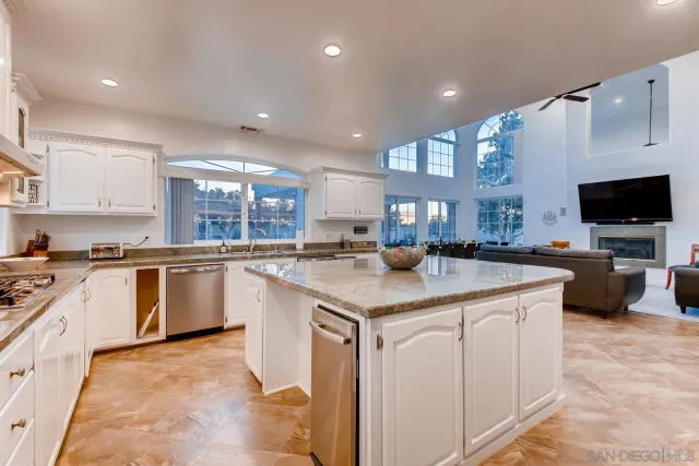a kitchen with granite countertop a sink stainless steel appliances and cabinets
