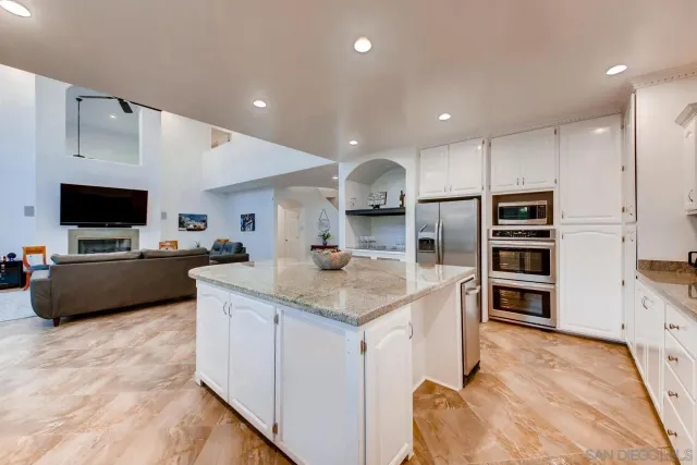 a kitchen with granite countertop stainless steel appliances and wooden floor