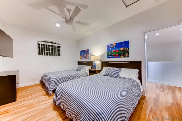 a spacious bedroom with a bed and a flat screen tv