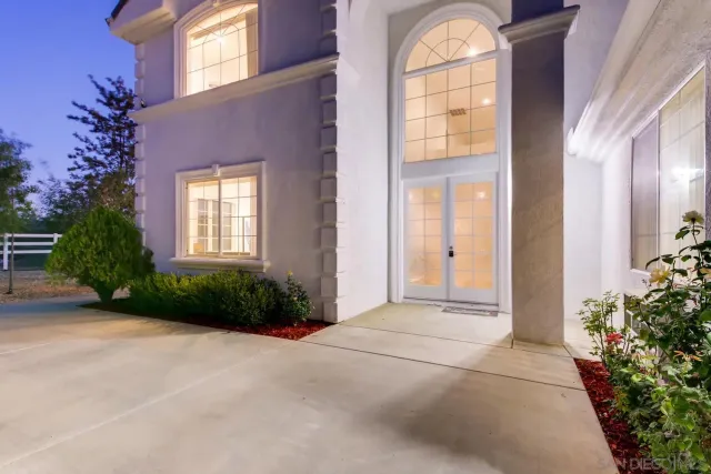 a view of a house with a yard and potted plants
