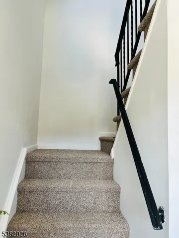 a view of staircase with white walls and railing