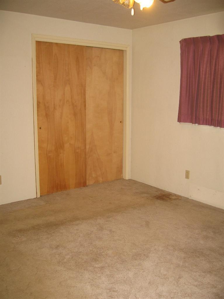 4988 Holland Loop Road Cave Junction, OR 97523 - Photo 25 of 35 an empty room with a wooden door