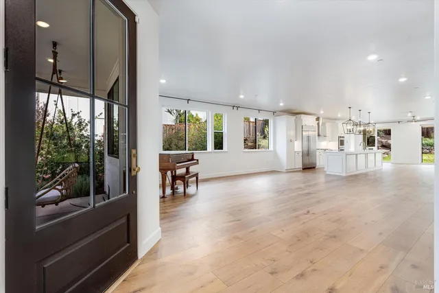 a view of a hallway to an empty room and wooden floor
