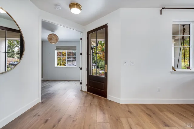 a view of a kitchen with a fridge and wooden floor