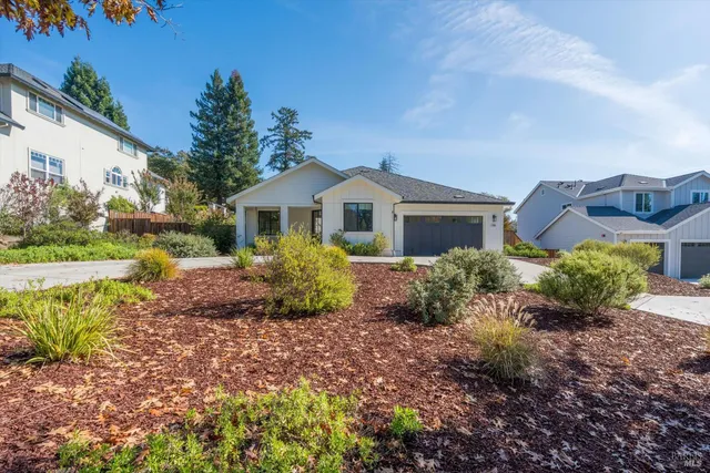 a front view of a house with a garden and yard