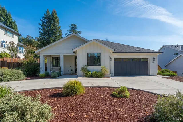 a front view of a house with a yard and trees