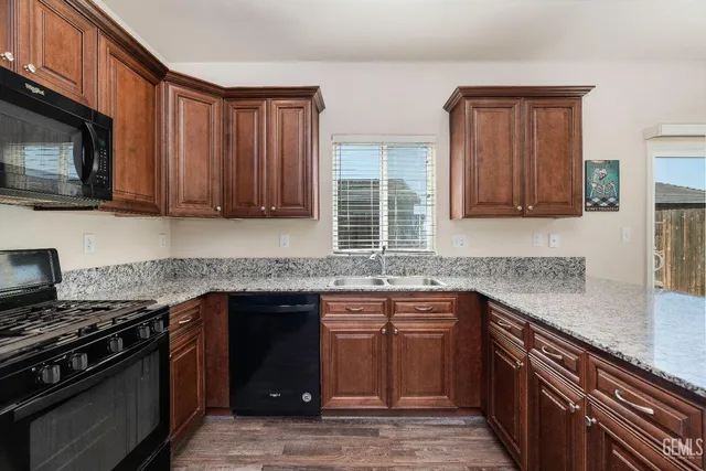 a kitchen with stainless steel appliances granite countertop a sink stove and microwave