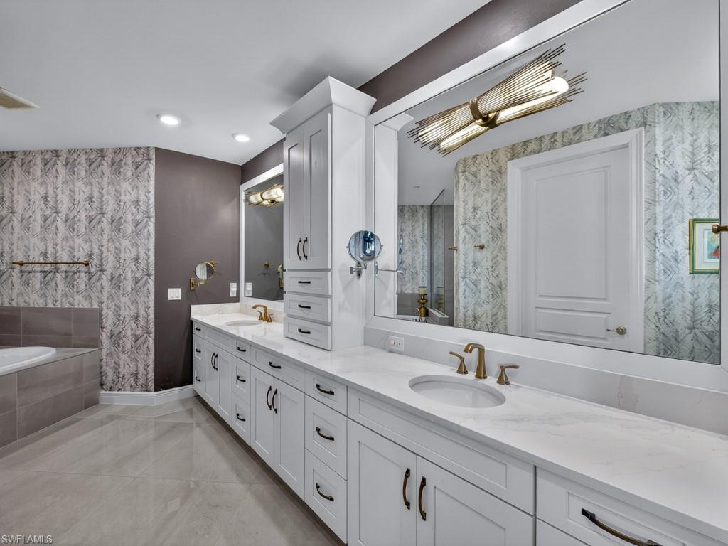 16371 Viansa Way, Unit 201 Naples, FL 34110 - Photo 16 of 42 a bathroom with a sink double vanity granite tub shower and a mirror