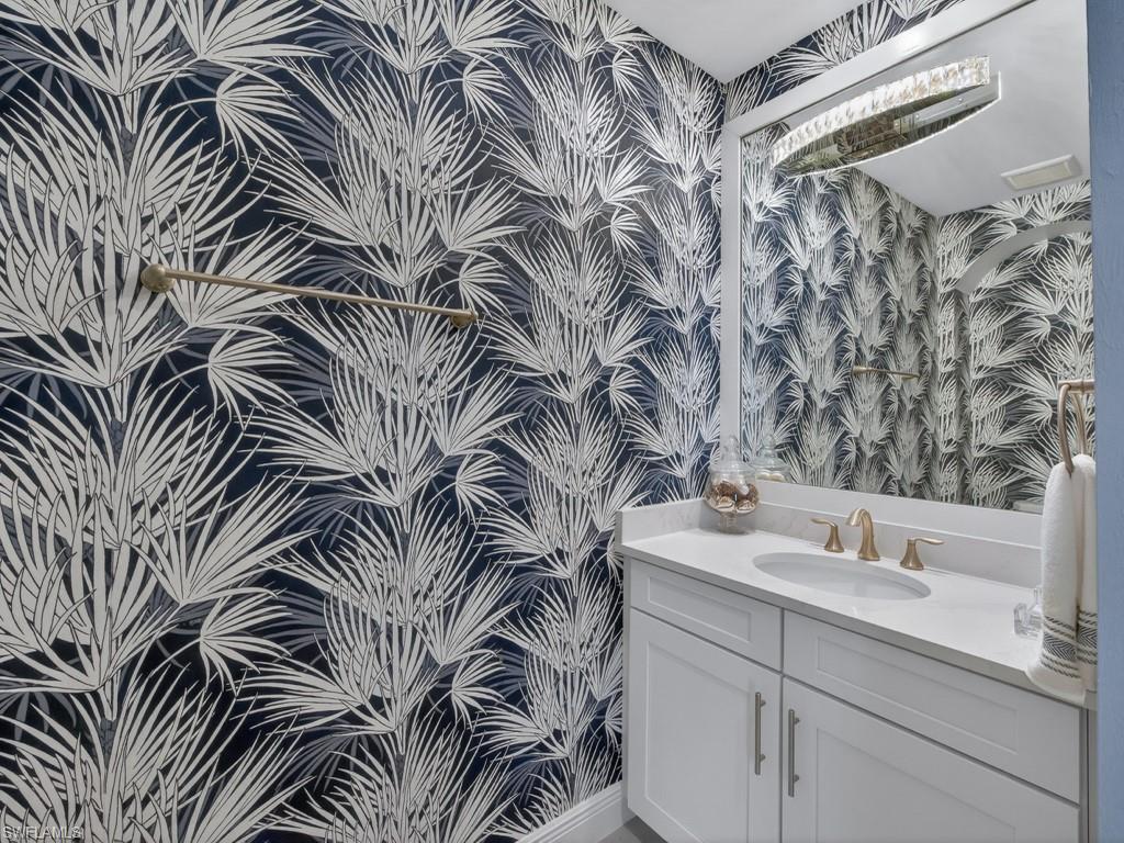 16371 Viansa Way, Unit 201 Naples, FL 34110 - Photo 20 of 42 a bathroom with a sink a mirror and a shower curtain