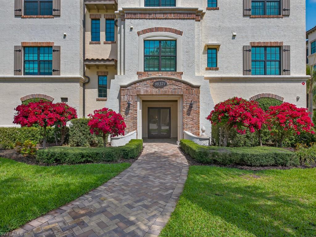 16371 Viansa Way, Unit 201 Naples, FL 34110 - Photo 3 of 42 a front view of house and yard with green space